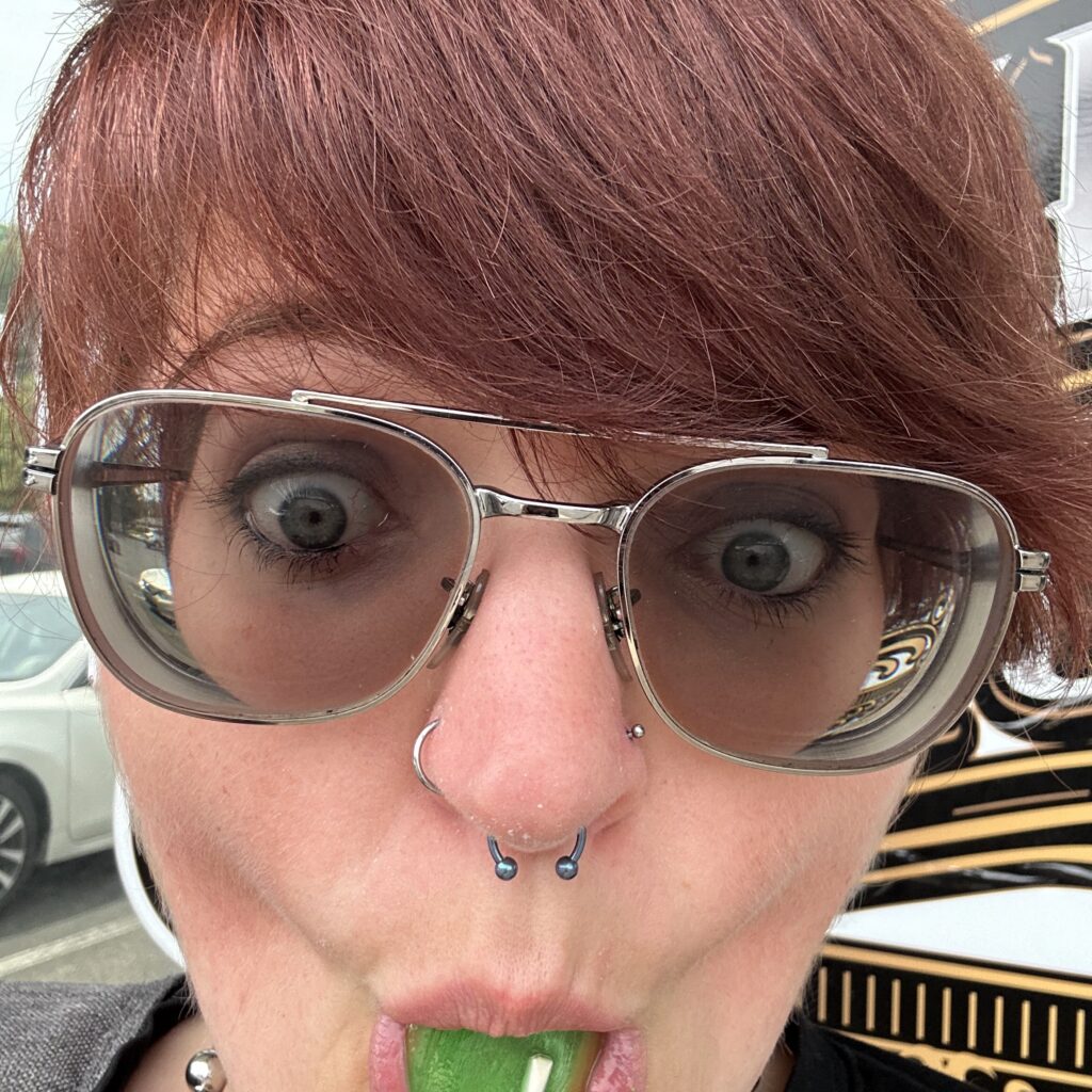 close up of lady with glasses sucking on lollipop